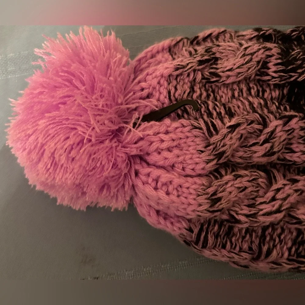Polar Extreme cable knit beanie with a pom pom and pink and black coloring.